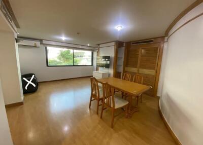 Dining area with wooden table and chairs, large windows, and ample lighting