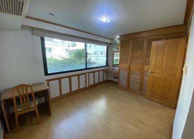 Bedroom with wooden furniture and large window