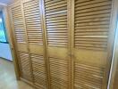 Wooden louvered wardrobe in bedroom