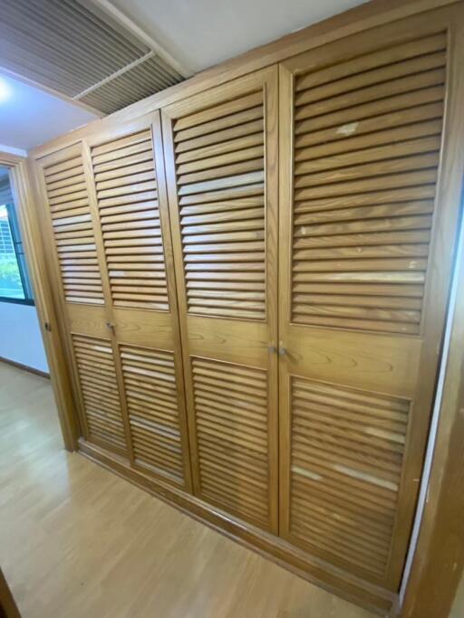 Wooden louvered wardrobe in bedroom