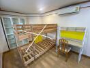 Bedroom with wooden bunk bed, chair, study desk, and air conditioner