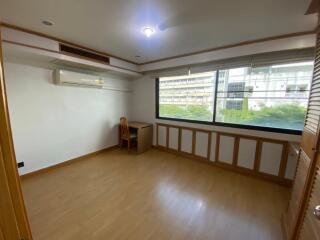 Spacious bedroom with large windows and wooden flooring