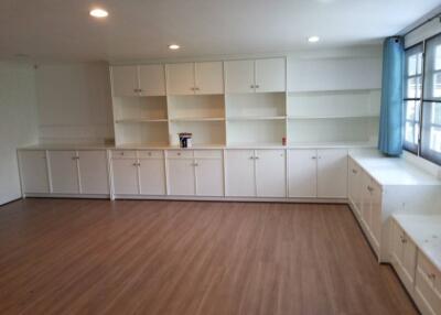 Spacious living area with built-in cabinets and hardwood floors