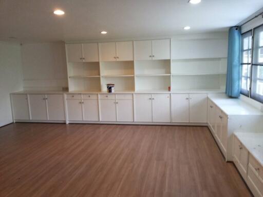 Spacious living area with built-in cabinets and hardwood floors