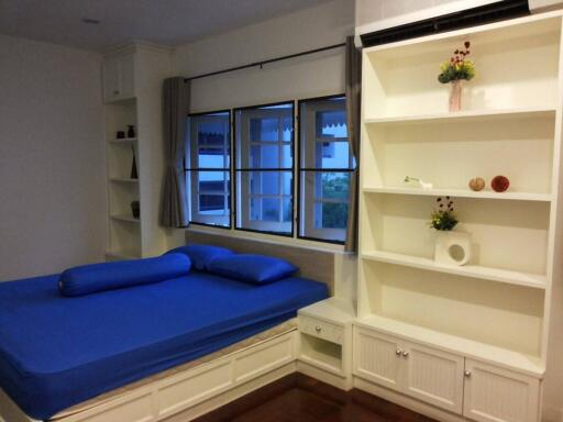 Bedroom with blue bedding and built-in shelves