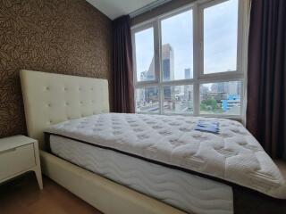 Bedroom with large window overlooking the city