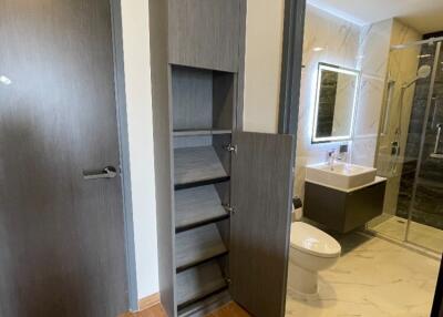 Modern bathroom with open shelving and closed door