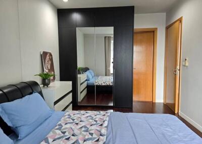 Modern bedroom with mirror wardrobe and blue bed linens