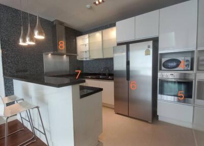 Modern kitchen with island counter, stainless steel appliances, and white cabinets