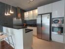 Modern kitchen with island counter, stainless steel appliances, and white cabinets