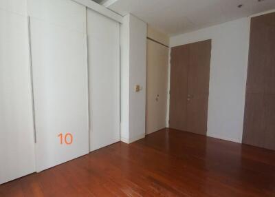 Empty bedroom with wooden floor and closet