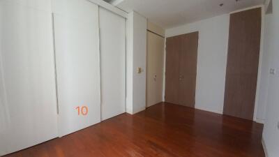 Empty bedroom with wooden floor and closet