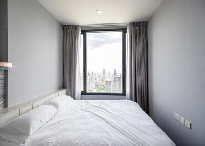 Bedroom with a view of the city skyline through a large window