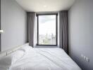 Bedroom with a view of the city skyline through a large window