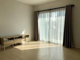 Bright living room with large window and wooden floor