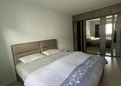 Modern bedroom with large bed and mirrored wardrobe