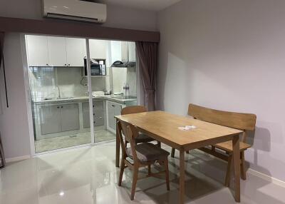 Simple dining area with a table, chairs, and adjacent kitchen