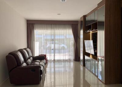 Spacious living room with a leather sofa and a large entertainment center