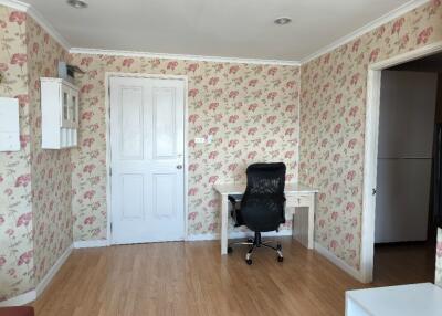 Bedroom with a desk and floral wallpaper