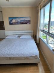 Bedroom with large window and scenic painting