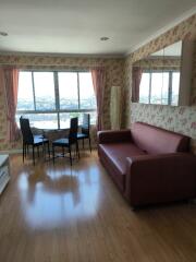 Living room with a red sofa, dining table, large windows, and floral wallpaper