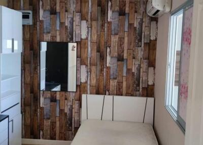 Cozy bedroom with wooden-patterned wall and white furniture