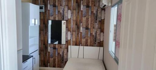 Cozy bedroom with wooden-patterned wall and white furniture