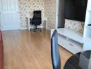 Living room with a TV, desk, and chairs