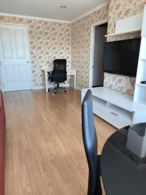 Living room with a TV, desk, and chairs