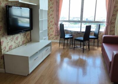 Living room with TV, dining area, and large window