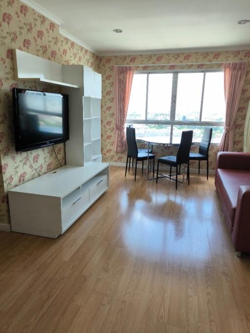 Living room with TV, dining area, and large window