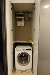 Compact laundry area with washing machine and storage