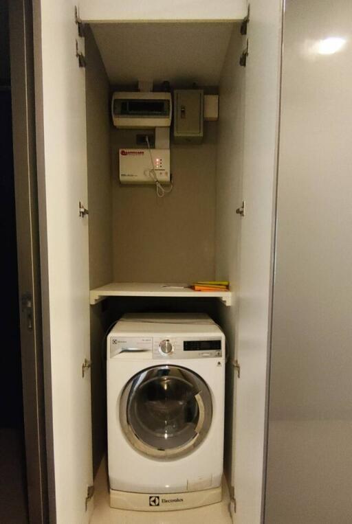 Compact laundry area with washing machine and storage