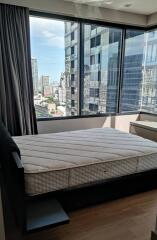 Bedroom with a large window and urban view