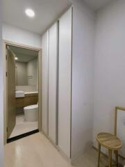 View of bathroom entrance with wardrobe and stool