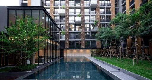 Modern apartment building with outdoor swimming pool and landscaped garden