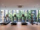 modern gym with large windows and fitness equipment