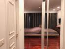 Bedroom with wooden floor and mirrored closet