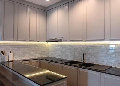 Modern kitchen with white cabinetry and under-cabinet lighting