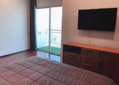 Bedroom with balcony access and mounted television