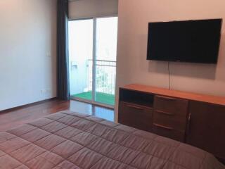 Bedroom with balcony access and mounted television