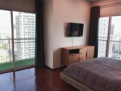 Spacious bedroom with large windows and balcony