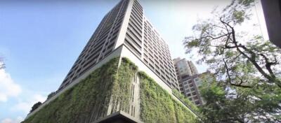 Exterior view of a modern high-rise building with greenery on lower levels