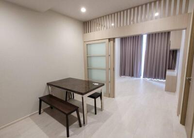 Modern dining area with seating and a view into the living room