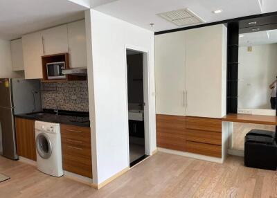 Modern kitchen area with integrated appliances and mirrored vanity unit