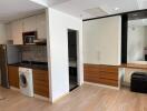 Modern kitchen area with integrated appliances and mirrored vanity unit