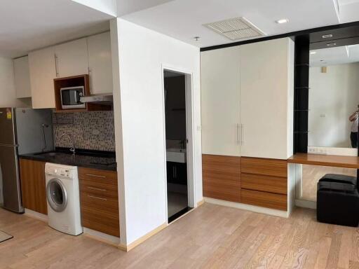 Modern kitchen area with integrated appliances and mirrored vanity unit