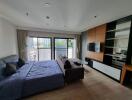 Modern bedroom with large bed, sofa, TV, and balcony view