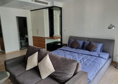 Bedroom with grey couch and blue bedding