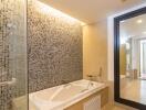 Modern bathroom with glass mosaic tiles and bathtub